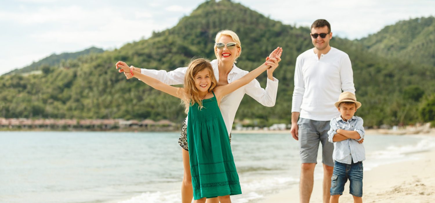 beautiful happy family posing on beach of tropical island